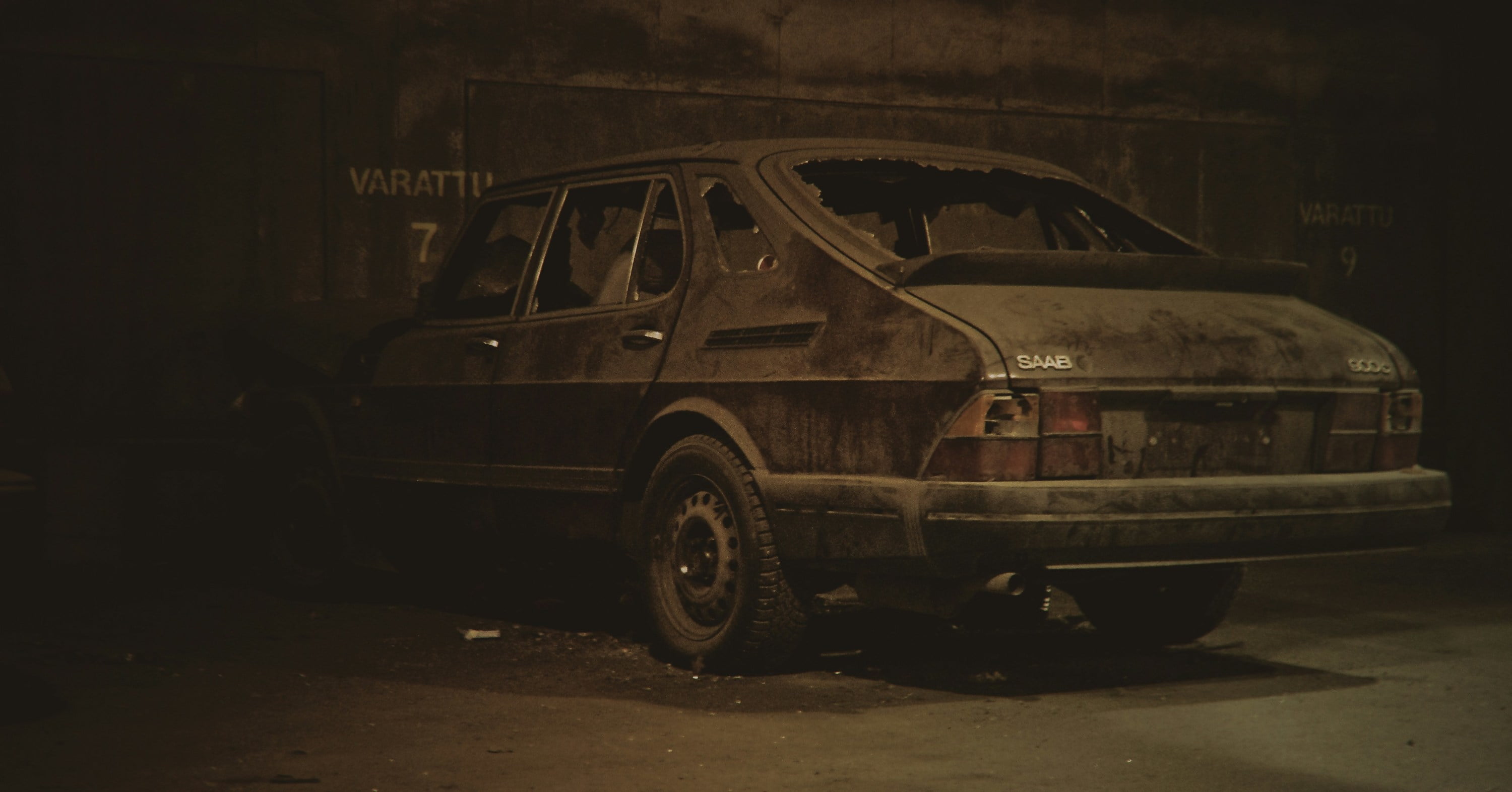 abandoned old black sedan with broken windows