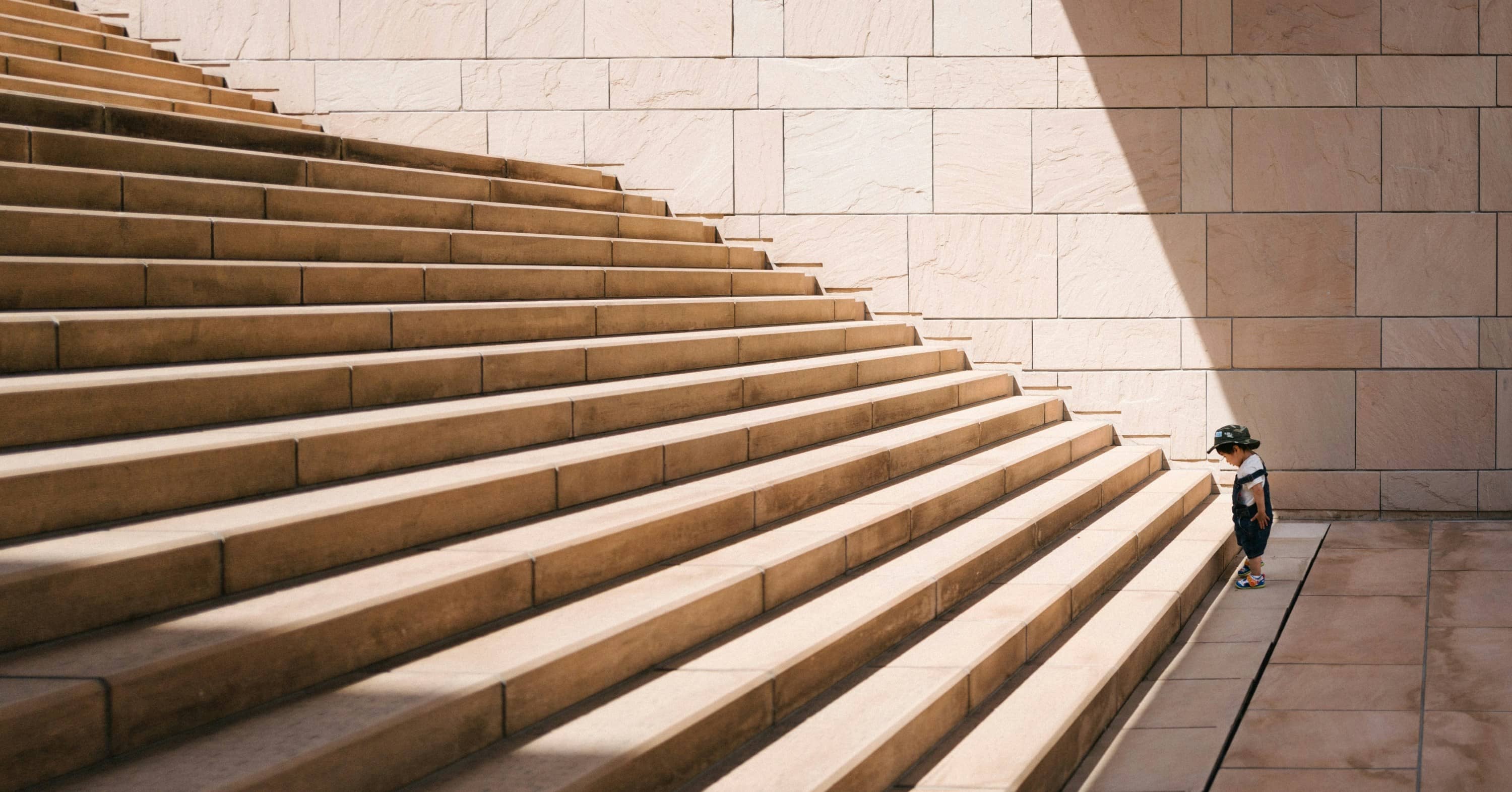 toddler's standing in front of beige concrete stair